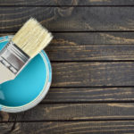 Paint bucket and brush on table